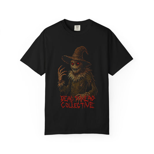 Black t-shirt featuring a terrifying scarecrow with glowing red eyes, jagged claws, and a twisted grin, wearing a tattered hat and outfit; beneath the figure, the words "DEAD DREAD COLLECTIVE" appear in jagged red font, evoking a gothic horror vibe.